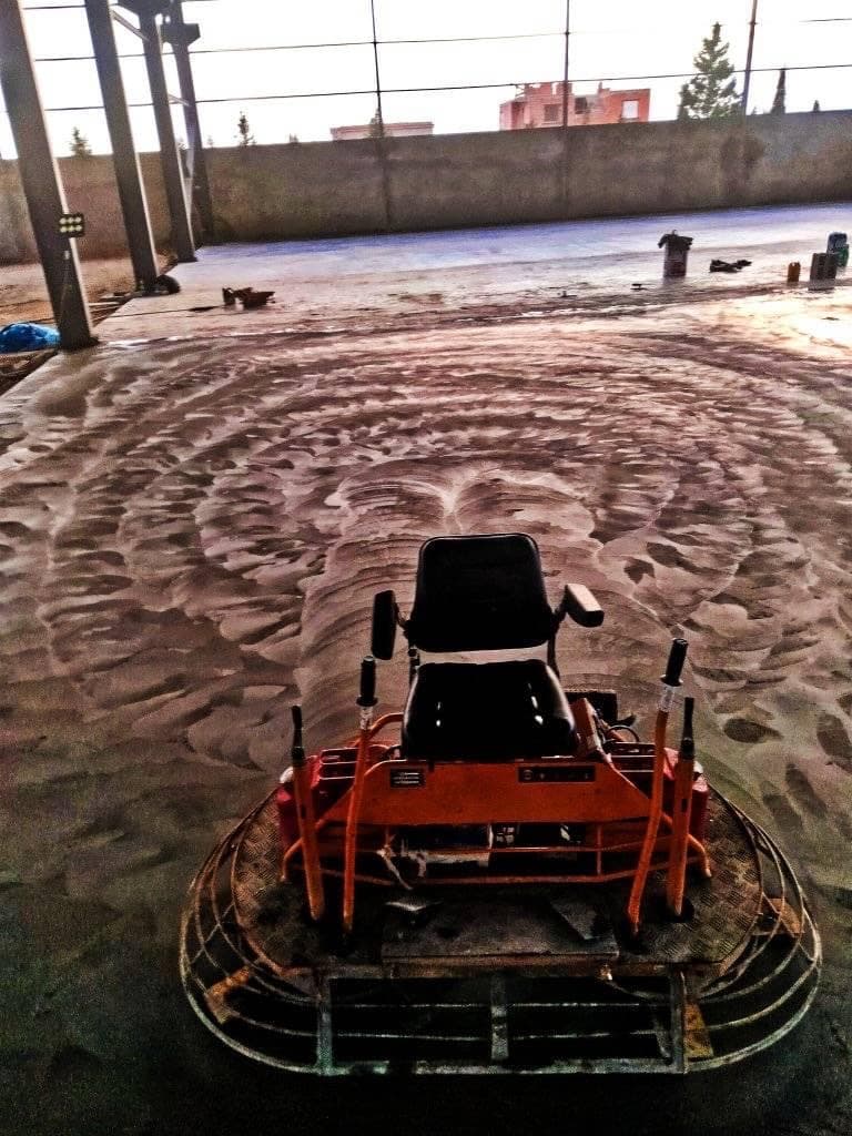 Power-troweling a stamped concrete patio to finish
