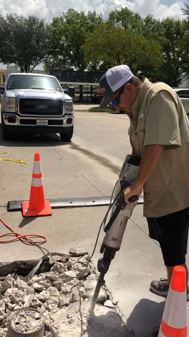 Breaking up old concrete with a jackhammer ahead of a replacement pour