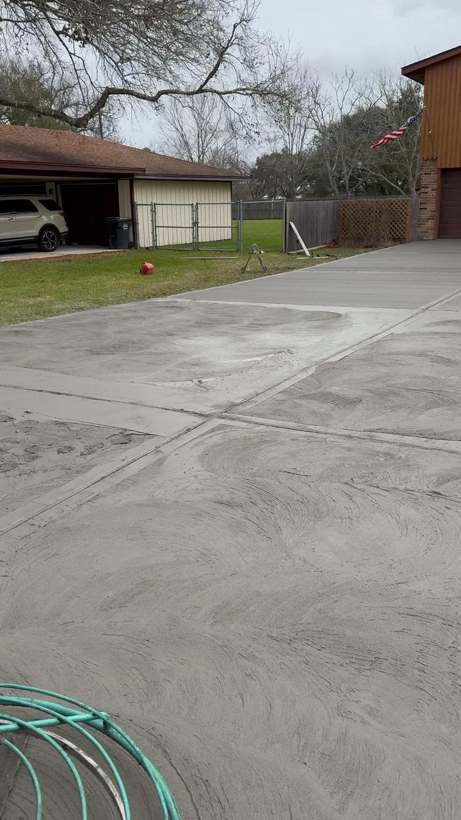 Broom-finished concrete driveway being hand-finished at a Houston-area home