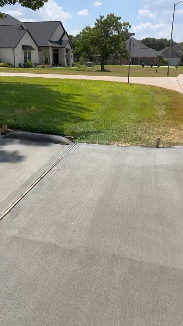 Broom-finishing the surface of a freshly poured concrete driveway