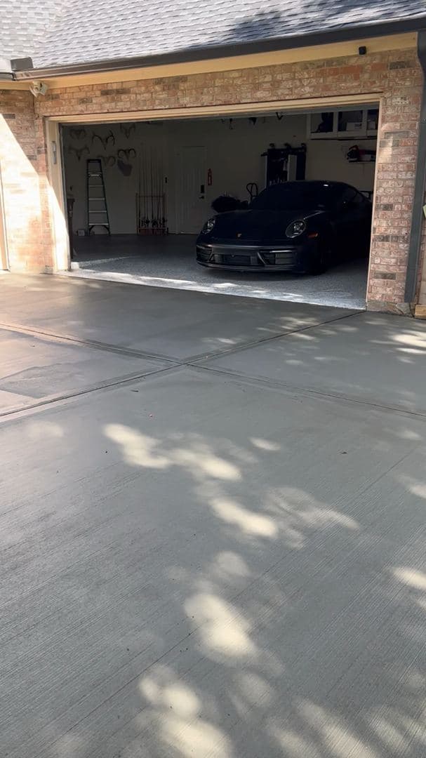 Finished concrete driveway leading to a three-car garage