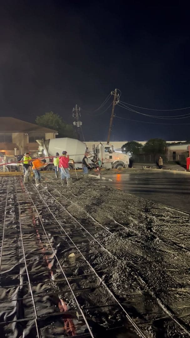Night pour on a commercial concrete project under work lights