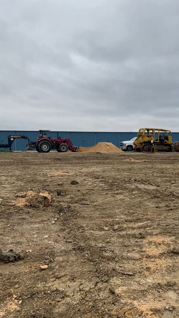 Grading a commercial site ahead of a concrete pour on an overcast day