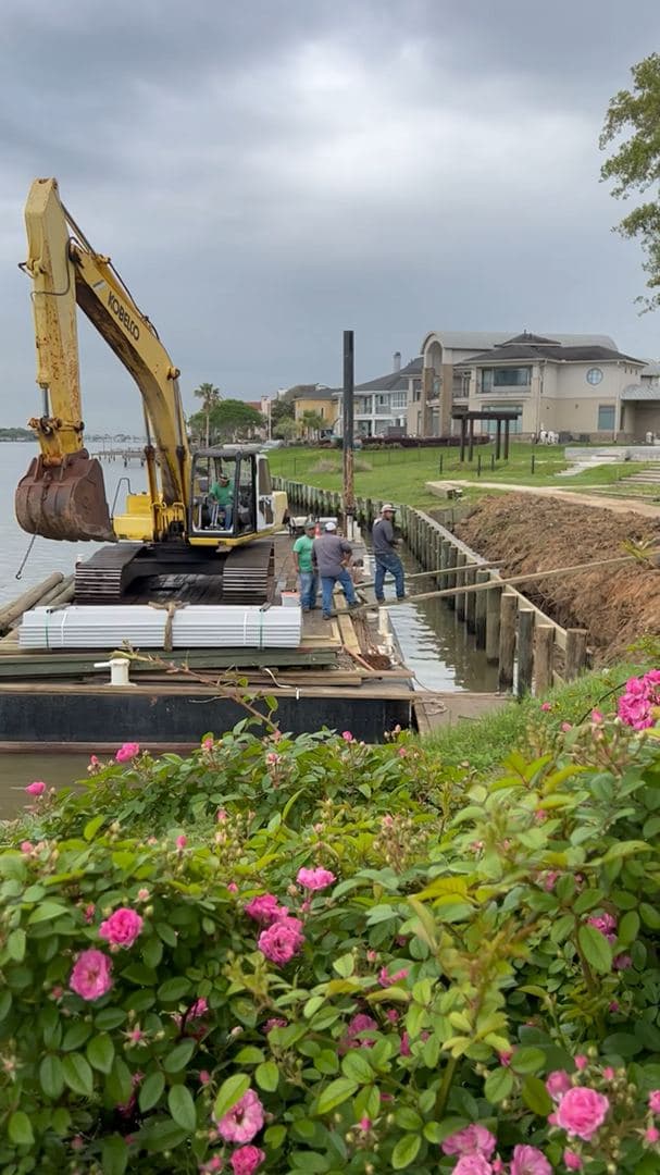 Excavating a trench along a residential fence line for site drainage