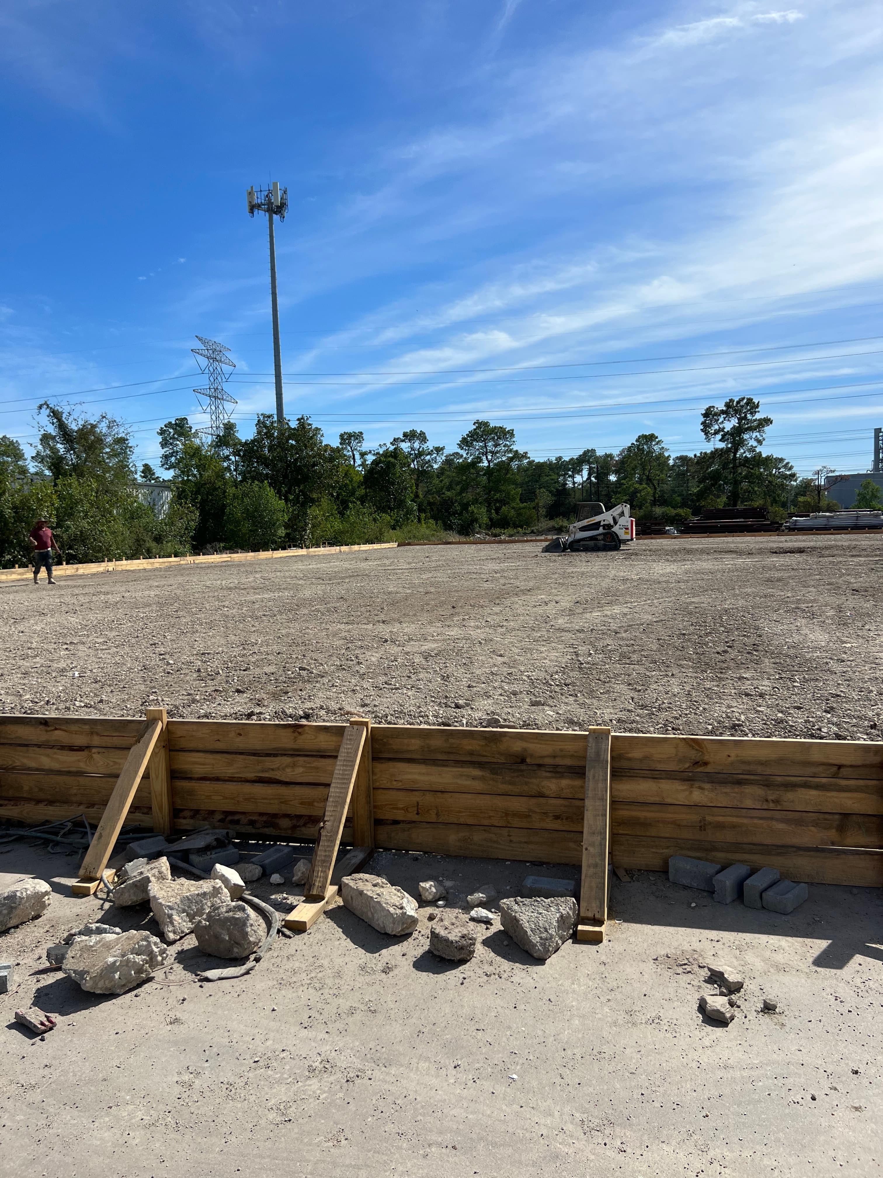 Finished concrete wall with rebar dowels along a property fence line